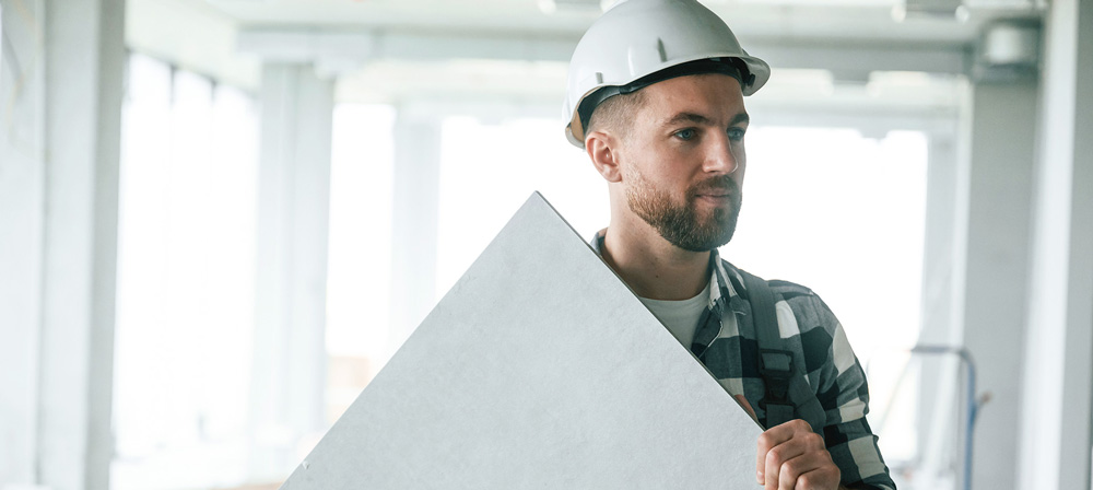 Trockenbaumonteur, Mann mit Wandpanel in der Hand